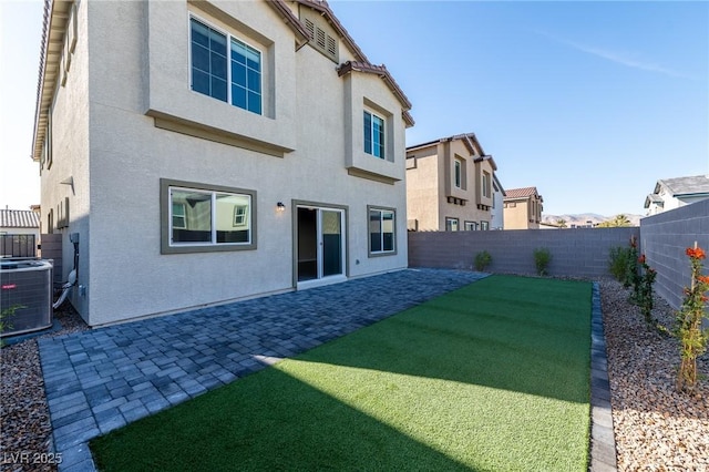 rear view of property featuring a patio area, central air condition unit, a fenced backyard, and stucco siding