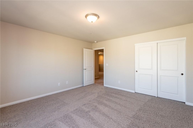 unfurnished bedroom featuring carpet, baseboards, and a closet