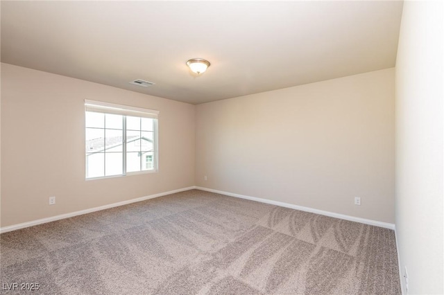 unfurnished room with carpet, visible vents, and baseboards