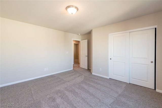 unfurnished bedroom featuring baseboards, carpet floors, and a closet