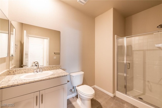 bathroom featuring vanity, baseboards, a stall shower, tile patterned flooring, and toilet