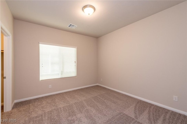 empty room with carpet flooring, baseboards, and visible vents