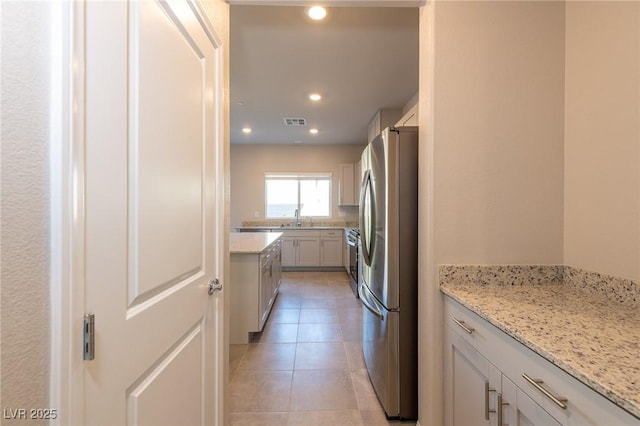 kitchen with light tile patterned floors, visible vents, recessed lighting, freestanding refrigerator, and a sink