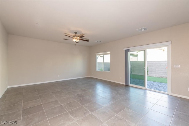 spare room featuring tile patterned floors, visible vents, baseboards, and ceiling fan