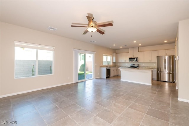 kitchen with visible vents, a center island, open floor plan, light countertops, and stainless steel appliances