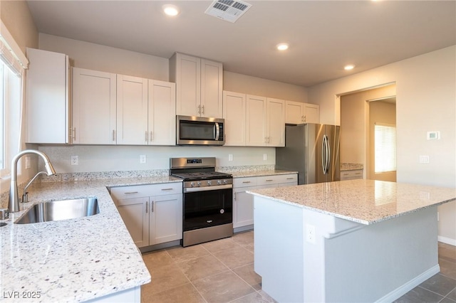 kitchen featuring visible vents, a center island, recessed lighting, stainless steel appliances, and a sink