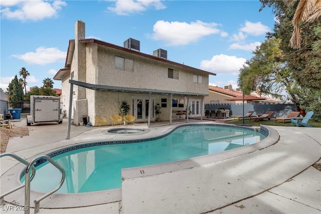 view of pool featuring a patio, fence, an in ground hot tub, central AC, and french doors