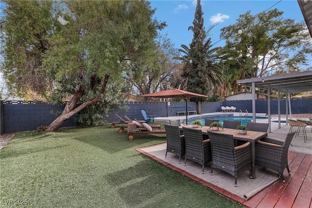 view of yard with a fenced in pool, outdoor dining area, and a fenced backyard