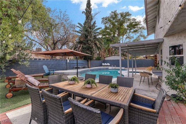 view of patio with outdoor dining area, a fenced backyard, and a fenced in pool