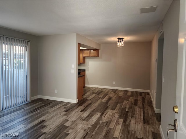 unfurnished living room with dark wood finished floors and baseboards