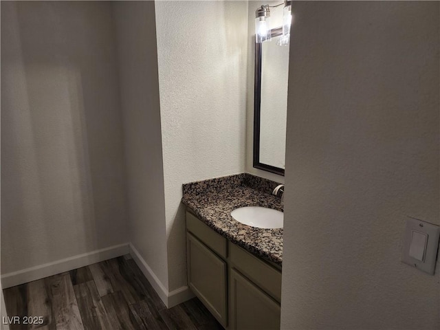 bathroom with vanity, baseboards, and wood finished floors