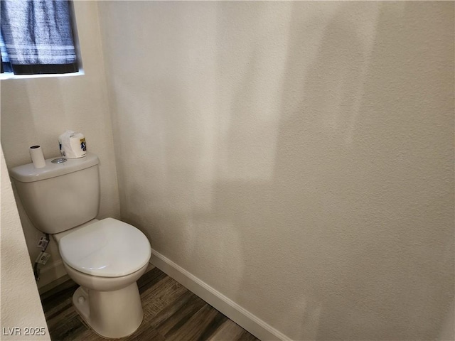 bathroom featuring baseboards, toilet, and wood finished floors