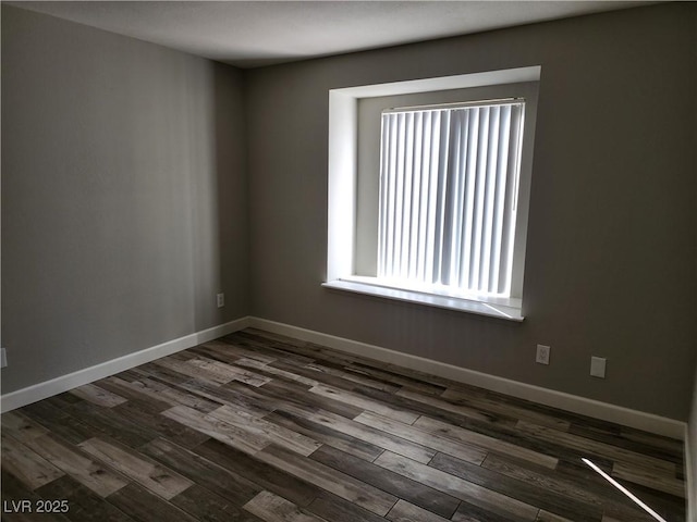 spare room with dark wood finished floors and baseboards