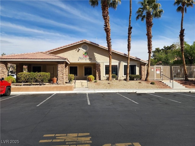 view of property with fence and uncovered parking