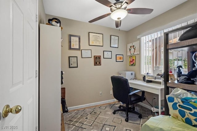 office space with a ceiling fan and baseboards