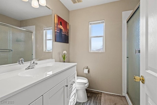 full bathroom featuring a wealth of natural light, a stall shower, toilet, and vanity