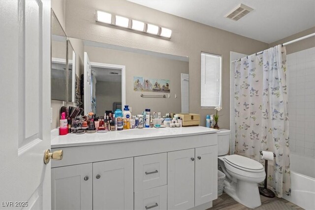 bathroom with visible vents, toilet, vanity, and shower / bath combo