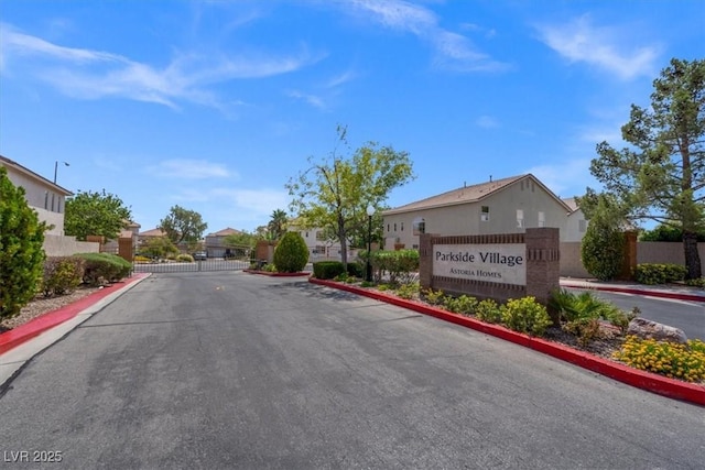 view of road with curbs, a residential view, a gated entry, and a gate