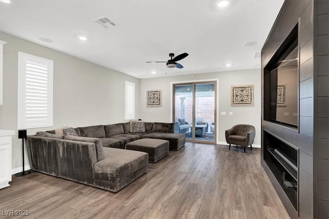 living room featuring visible vents, recessed lighting, a ceiling fan, and wood finished floors