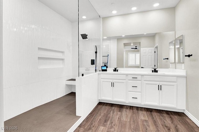 bathroom featuring a sink, wood finished floors, and a walk in shower