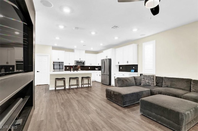 living area featuring recessed lighting, light wood-style floors, visible vents, and ceiling fan