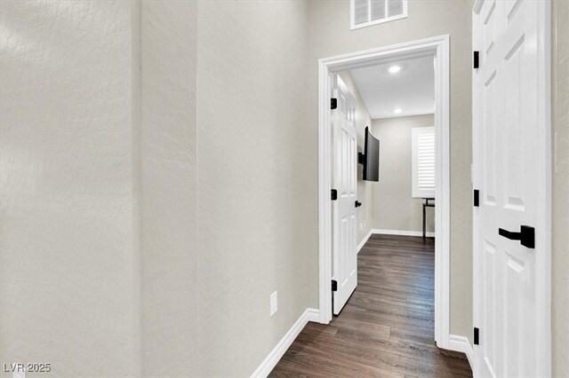 hallway with recessed lighting, visible vents, baseboards, and dark wood-type flooring