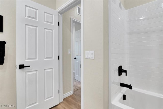 full bathroom featuring visible vents, baseboards,  shower combination, and wood finished floors