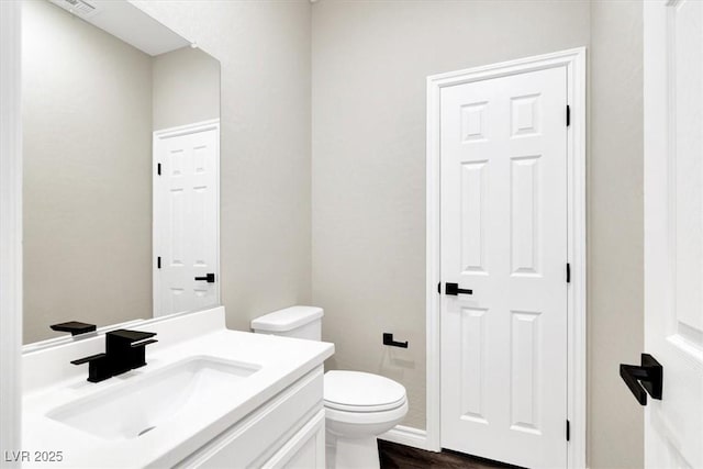 bathroom featuring vanity, toilet, and wood finished floors