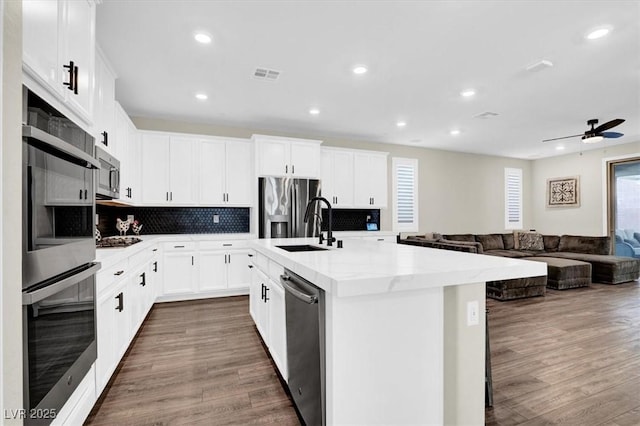 kitchen with dark wood-style floors, visible vents, stainless steel appliances, and ceiling fan