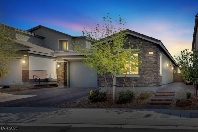 view of front of property featuring stucco siding, stone siding, a garage, and driveway