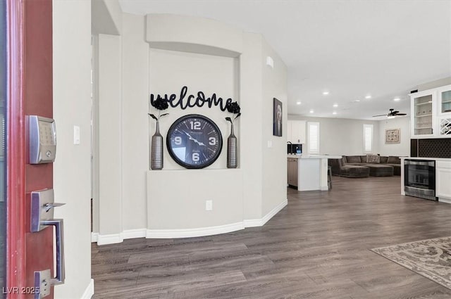 entrance foyer with a ceiling fan, baseboards, recessed lighting, dark wood-type flooring, and wine cooler