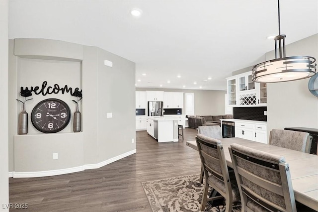 dining space featuring dark wood-type flooring, wine cooler, recessed lighting, and baseboards