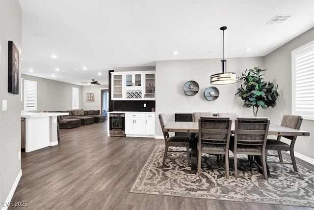 dining space with visible vents, dark wood-type flooring, baseboards, wine cooler, and recessed lighting