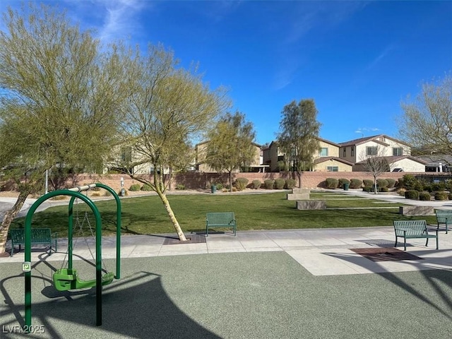 view of property's community featuring a lawn and fence