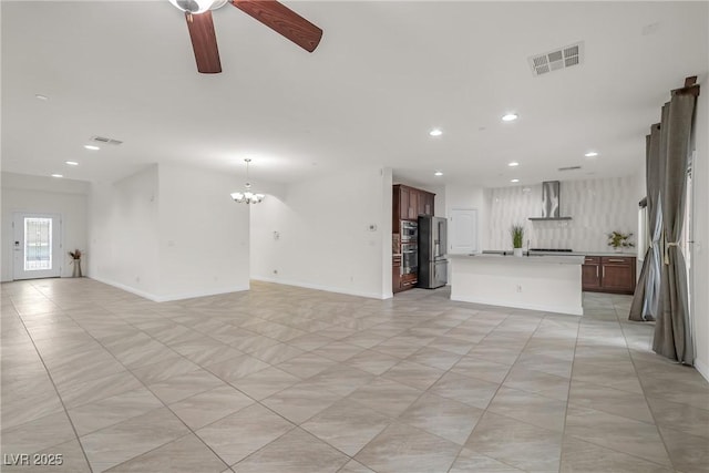 unfurnished living room with recessed lighting, visible vents, baseboards, and ceiling fan with notable chandelier