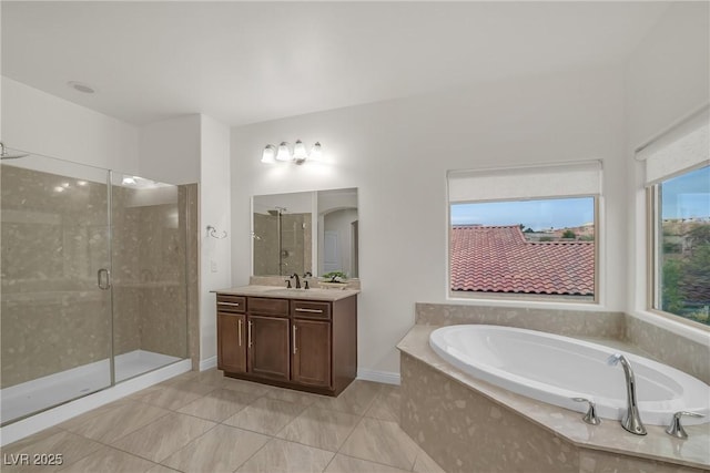 bathroom featuring baseboards, a garden tub, a stall shower, and vanity