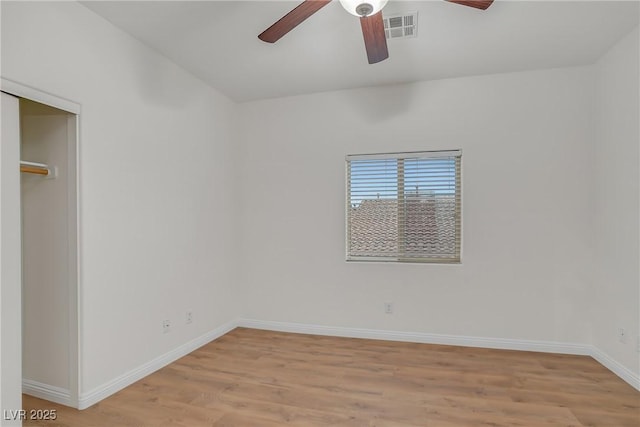 unfurnished bedroom featuring visible vents, a closet, light wood finished floors, baseboards, and ceiling fan