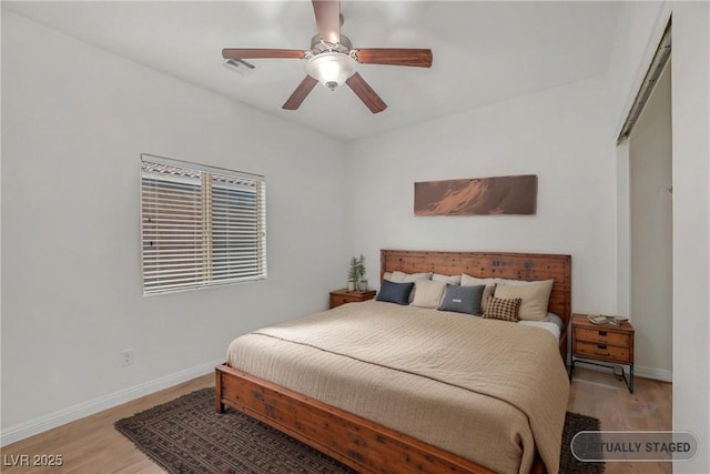 bedroom featuring visible vents, baseboards, light wood-style floors, and ceiling fan