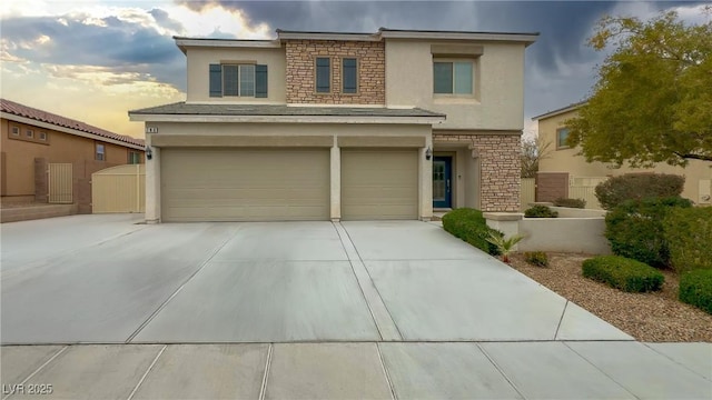 view of front of property featuring an attached garage, stone siding, driveway, and stucco siding