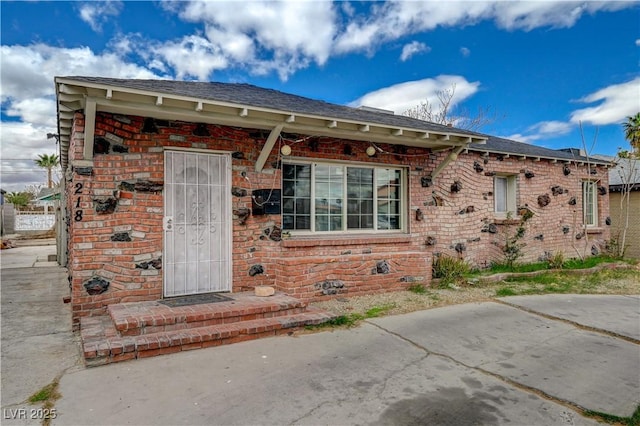 view of front of property with crawl space and brick siding