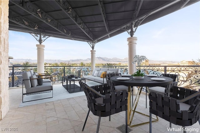 view of patio / terrace with outdoor dining space, a mountain view, and an outdoor hangout area