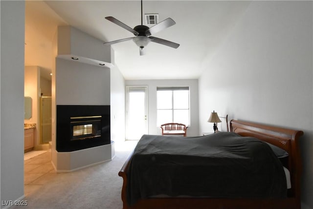 bedroom with visible vents, ensuite bath, a multi sided fireplace, carpet flooring, and lofted ceiling