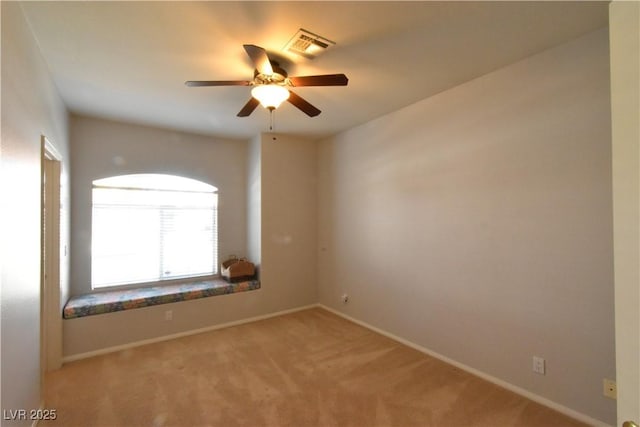 empty room with light carpet, visible vents, ceiling fan, and baseboards