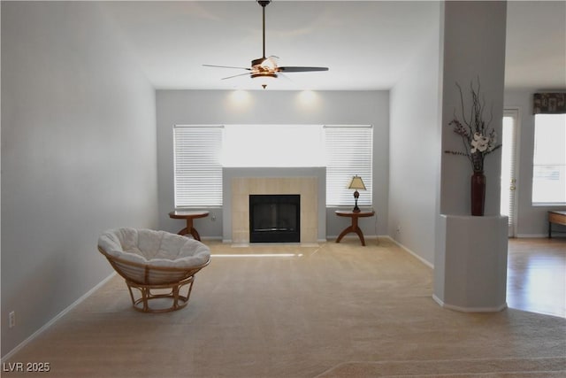 living area with carpet flooring, baseboards, ceiling fan, and a fireplace