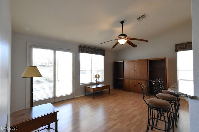 interior space featuring vaulted ceiling, visible vents, light wood finished floors, and ceiling fan