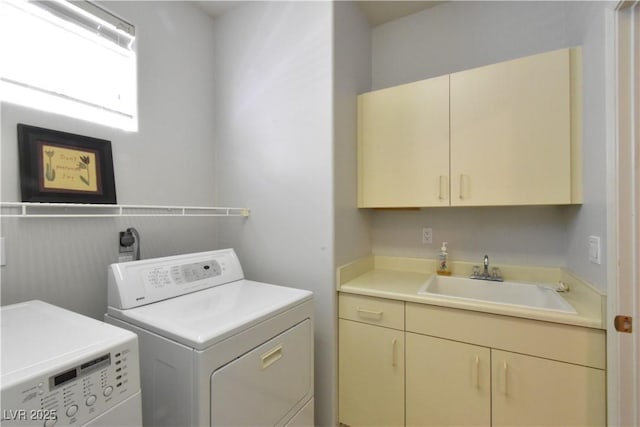 laundry area featuring washer and clothes dryer, cabinet space, and a sink