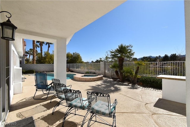 view of patio featuring a fenced backyard and a pool with connected hot tub