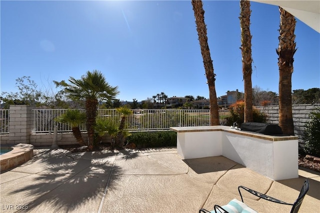 view of patio with a grill, exterior kitchen, and fence