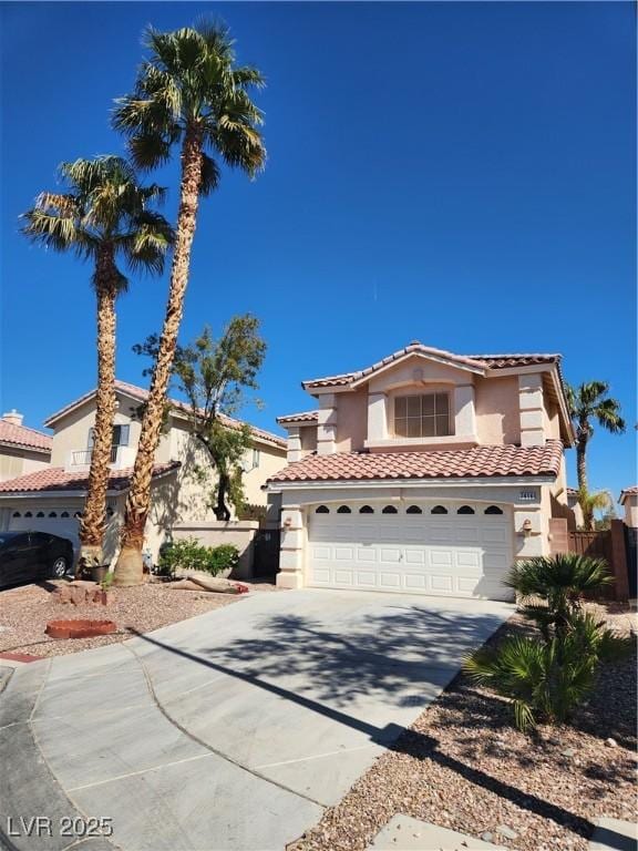 mediterranean / spanish home featuring fence, driveway, stucco siding, a garage, and a tile roof