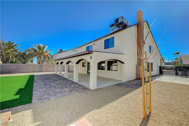 back of property with a patio area, stucco siding, and a fenced backyard